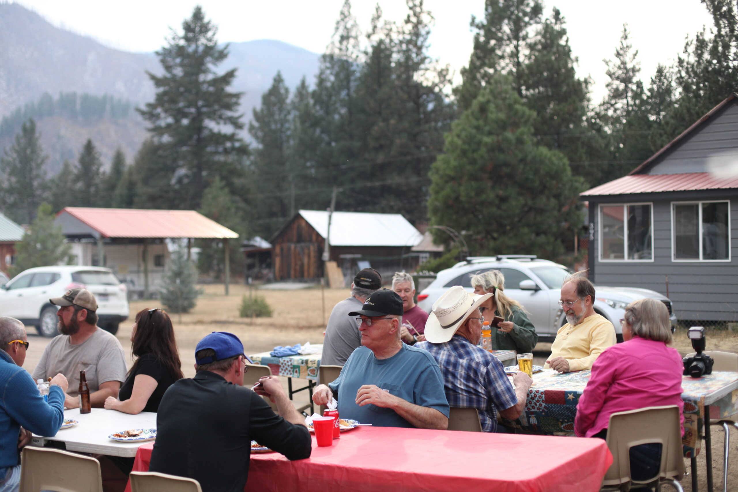 Community members gathered around tables at an outdoor town event in the West Central Mountains